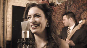 A singer in the foreground with a bass player in the background