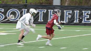 Two lacrosse players in action