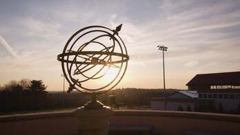 A sculpture in front of the sun